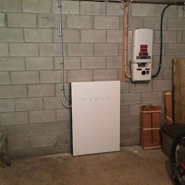Tesla power bank on brick wall